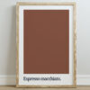 A framed wall art print featuring a solid brown background with the text "Espresso macchiato" in bold black typography at the bottom, set against a light wall.