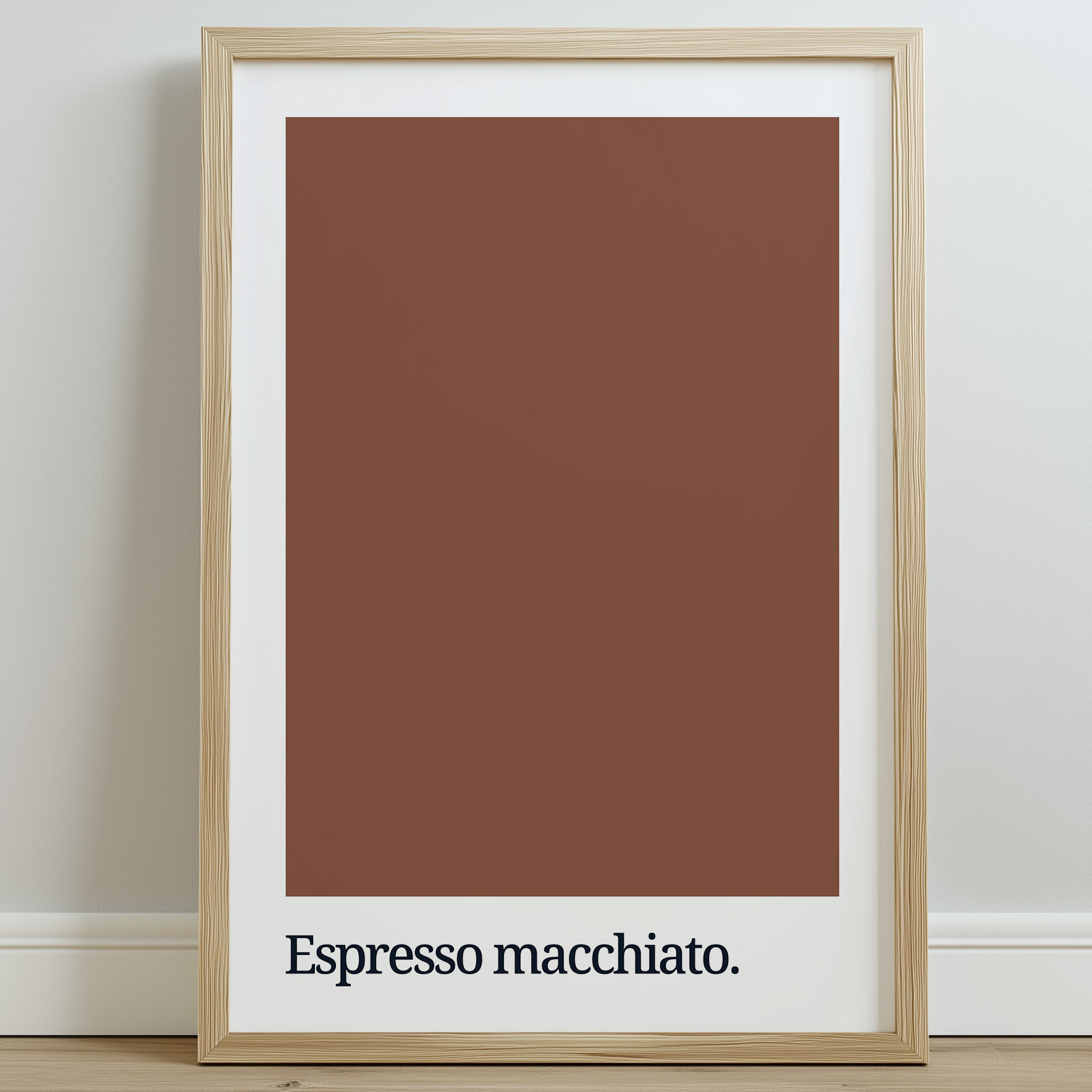 A framed wall art print featuring a solid brown background with the text "Espresso macchiato" in bold black typography at the bottom, set against a light wall.