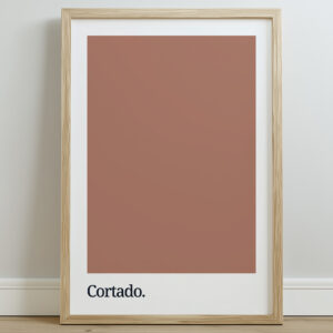 Framed poster featuring a solid terracotta color swatch with the word "Cortado." printed in bold black typography at the bottom, set against a light wall.